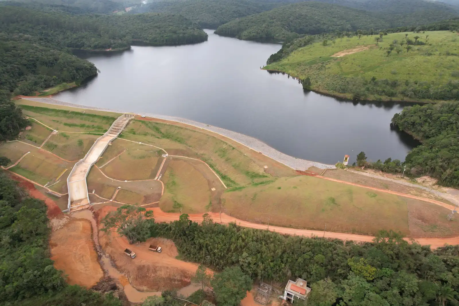 Vista aérea de barragem, reservatório e estruturas hidráulicas