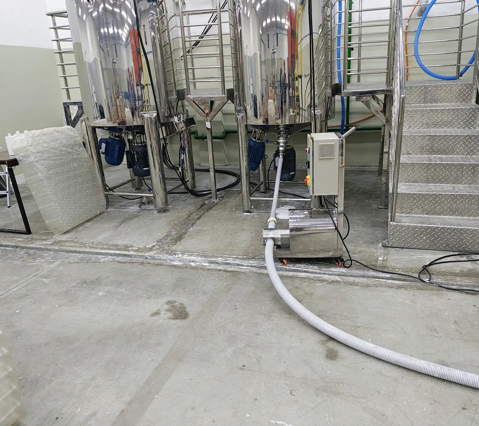 Tanques de processo e canaletas de drenagem no piso industrial